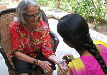 Henna painting on hand, women travel groups in India.